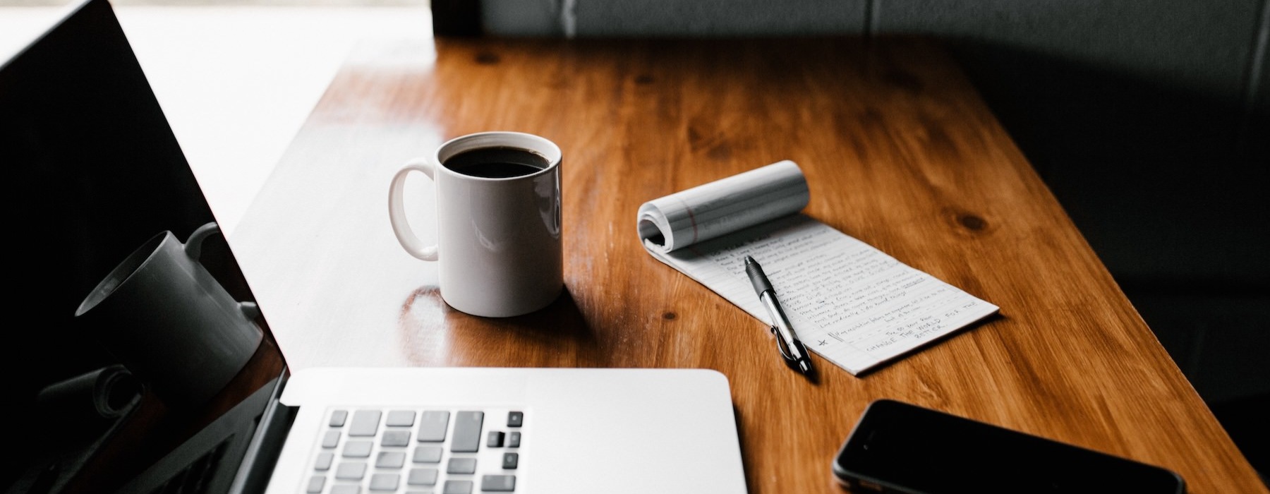 a laptop and a cup of coffee on a desk